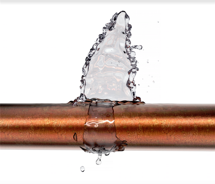 a broken copper pipe with water leaking from it